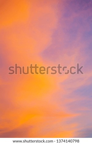 Orange and pink bright sky background. Wallpaper or a screen saver for desktop or smartphone. Summer beautiful and colorful sunset sky with clouds.