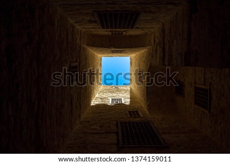 A beautiful and gorgeous cloudless sky picture taken from floor. Classical windows and walls framing the sky. Photo taken in the Citadel of Qaitbay, Alexandria, Egypt