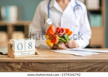Calendar with date of March 8 on table of female doctor