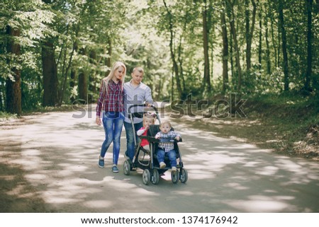 Beautiful long-haired mother with her husband and two children walk in the forest