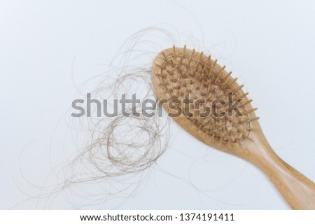 Hair loss in woman hands and comb.