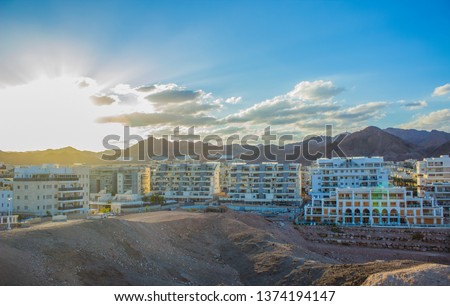 Middle East Israeli modern city in desert view picture opposite sun light with glared and rays on vivid blue sky in evening time before sunset