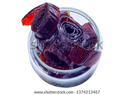 Homemade organic vegetarian natural pastille in glass bank. Slices of fruit paste in rolls. Delicious healthy candies made from berries and fruit. Isolated on white background. With clipping path.