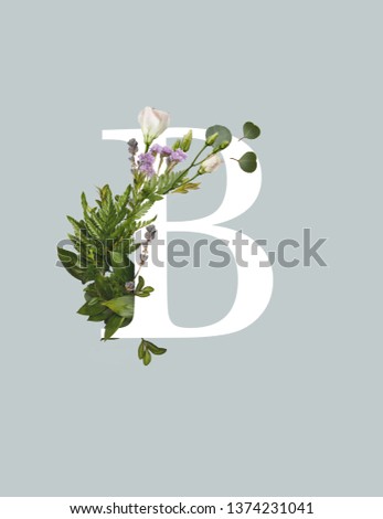 white letter B with eustoma flowers and green fern leaves isolated on grey