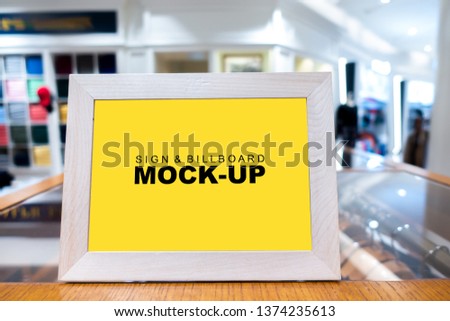 Mock up vertical blank banner or signboard in wooden frame with clipping path to show promotion or discount in shop clothing, yellow screen empty space for insert text or advertising in shopping mall