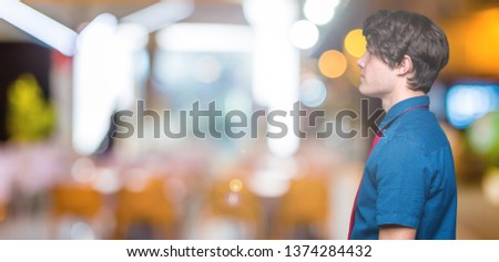 Young handsome business man wearing red tie over isolated background looking to side, relax profile pose with natural face with confident smile.