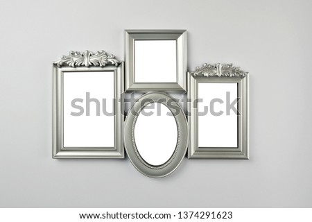 (Clipping path) Blank picture frames hanging on wall