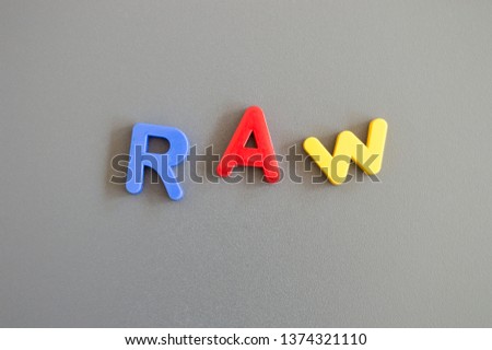 Colorful letters spelling word raw on grey background