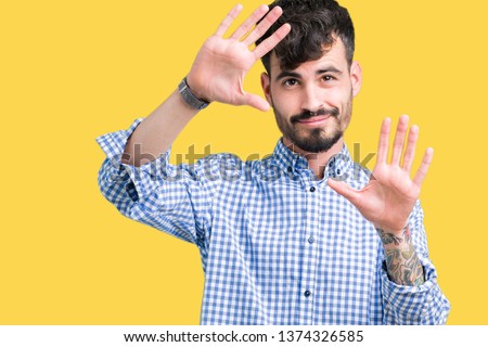 Young handsome business man over isolated background Smiling doing frame using hands palms and fingers, camera perspective