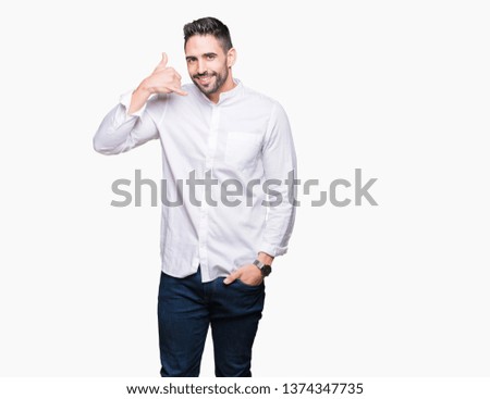 Young business man over isolated background smiling doing phone gesture with hand and fingers like talking on the telephone. Communicating concepts.