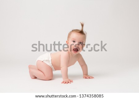 Cute little baby in diapers crawling on white background,bright picture of crawling curious baby over white backgroubd