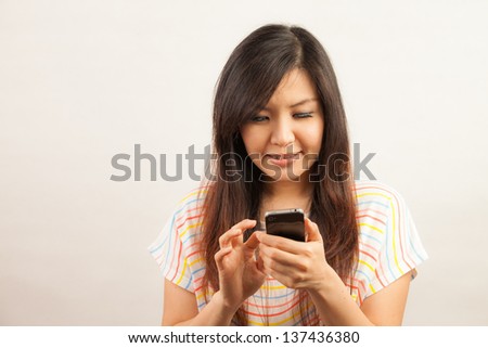 Young Asian woman woman text messaging