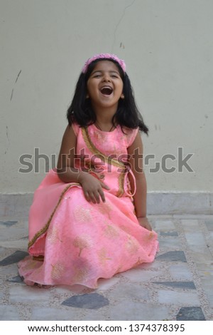  smiling indian little girl in pink dress enjoying with happiness
