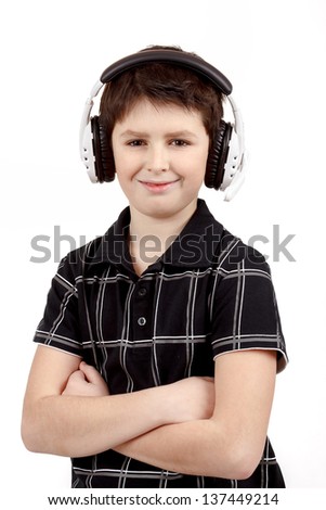 Portrait of a happy smiling young boy listening to music on headphones against white background