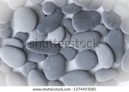 Spa background with grey stones, gray modern background, cover, template with round gray stones, flat lay. Copy space for your text. Stones scattered on a gray background.