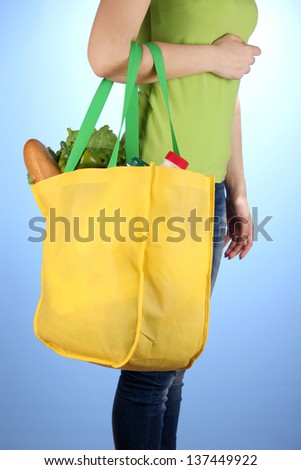 Girl with shopping bag on blue background