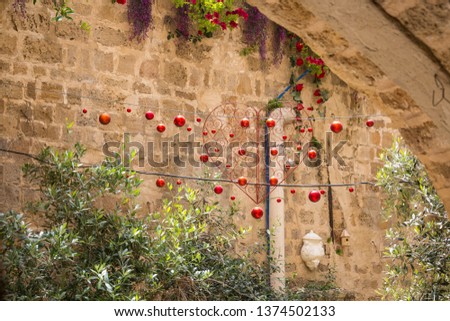A festive red garland of balls and a heart in the middle weighs in a street in the old city of Jaffa in Tel Aviv