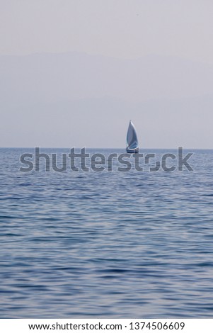 Various shades of blue for this picture of a sailboat on Lake of Geneva (Morges, Switzerland)                              