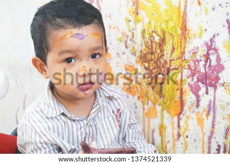 
Happy asian boy doing artist activities on the white wall. He siting and smile. He was happy with his colorful of art work.