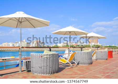 Parasol with empty seat of open air cafe near the sea. Sea landscape.