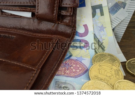 Brown leather wallet with money euro inside it. Macro photo.