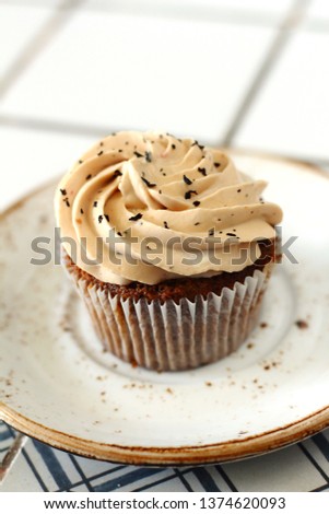 Chocolate homemade cupcakes with earl gray tea buttercream frosting on white plate. Dessert bakery style food photo 