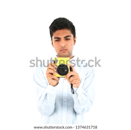 Unhappy young arab man holding a yellow camera against a white background