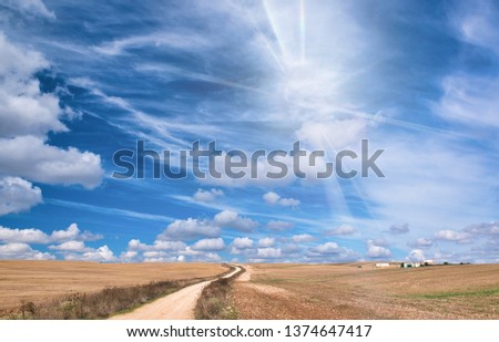 Beautiful windy countryside road against blue sky with clouds. Holiday and vacation concept.