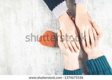 man and woman hand heart on gray desk