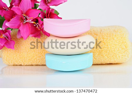Colored soap bars, yellow towel, pink flowers