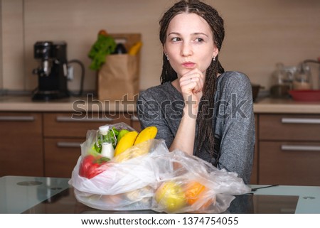 Girl thinks that would refuse to use a plastic bag to buy products in the store. The concept of environmental protection and the abandonment of plastic