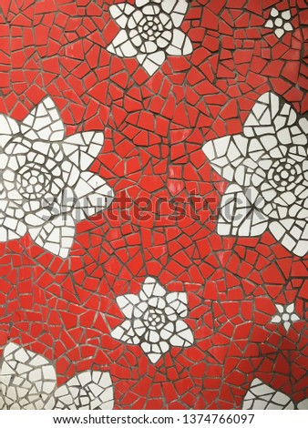 mosaic wall with an abstract image of white flowers on red background