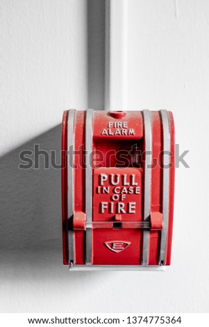 red fire alarm on a white wall