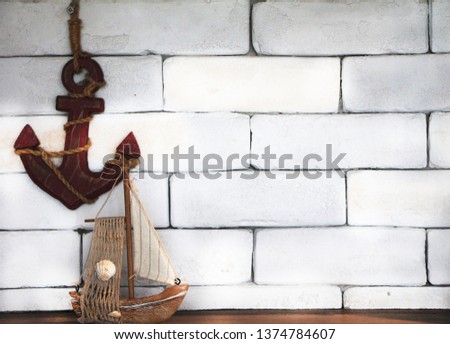 anchor with reproduce boat on white brick wall background.