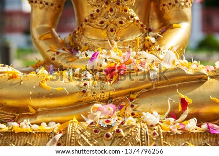 Flowers on Buddha statue after pouring water in Thai new year 