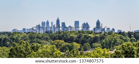 Downtown Atlanta Skyline showing several prominent buildings and hotels under a blue sky as seen from Buckhead in North Atlanta