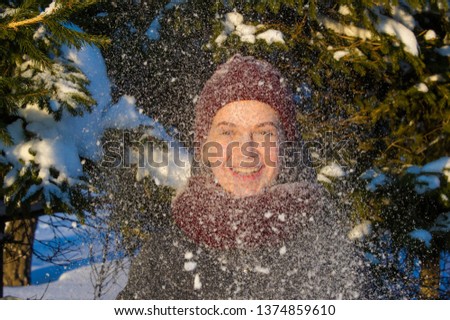 Photo of the girl on the background of snowy fir paws. Fluffy snow. red knitted hat. it's cold outside