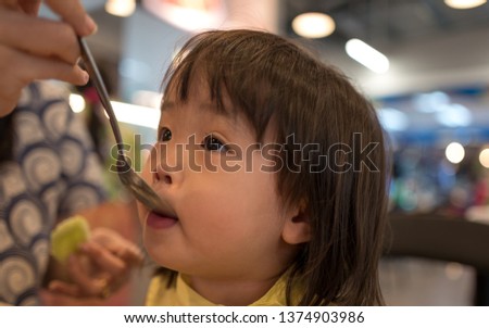 Close-up pictures of cute little girls who are taking medicine with a silver spoon