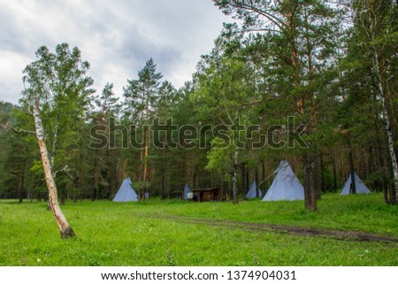 Traditional Indian camp in the green forest in Altai Mountains near Askat and Chemal village. Russian summer in Siberia.