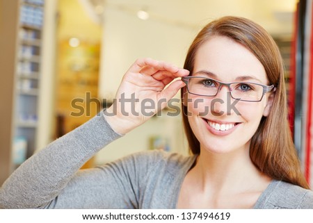 Attractive woman with new glasses in optician retail store Royalty-Free Stock Photo #137494619