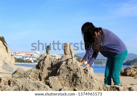 Woman doing Stone Balancing in Praia do Farol, Vila Nova de Milfontes, Portugal