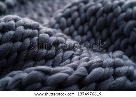 Merino wool handmade knitted large blanket, super chunky yarn, trendy concept. Close-up of knitted blanket, merino wool background. designer blanket made of beige smoky wool Royalty-Free Stock Photo #1374976619