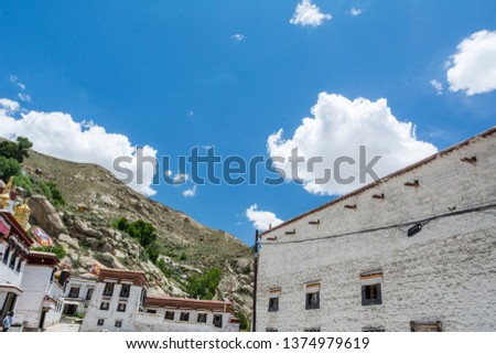 Architecture of white temples in Sera Monastery located in Lhasa, Tibet. Background with sunny blue sky and clouds.