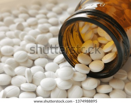 
Tablets and medicine bottles on a white background.