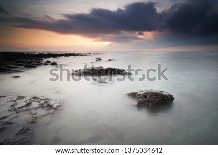 beautiful lanscape.  sunrise with smooth water and rocks.(long exposure). 