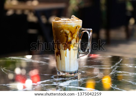 Glass with cold brew coffee and milk on marble table