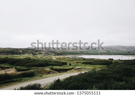 Grense Jakobselv. Finnmark county on the shore of the Barents Sea on a foggy day. Arctic Northern Norway landscapes. A southbound picture of Grense Jakobselv village. View of the mountains and fjords