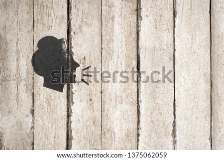 Speaking female silhouette on wooden background. Woman conversation icon illustration isolated on white background. Head, people, listen and speak icon, flat design. Part of a series. Copy space.