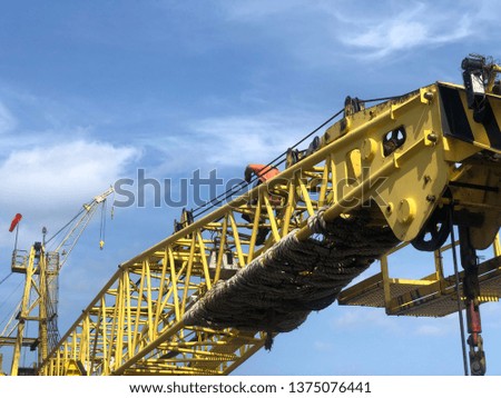 offshore tender rig crane or Derrick of Tender Assisted Drilling Oil Rig (offshore Barge Oil Rig) on The Production Platform During broad daylight with offshore worker and wind sock