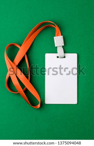 Blank security tag with a red stripe neck on a green background. Place for text, layout.